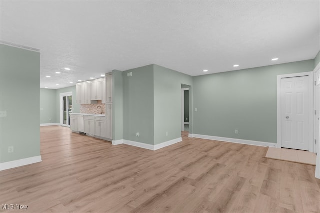 6937 Reynolds Rd, Mentor, OH 44060 - unfurnished living room featuring a sink, light wood-type flooring, recessed lighting, and baseboards