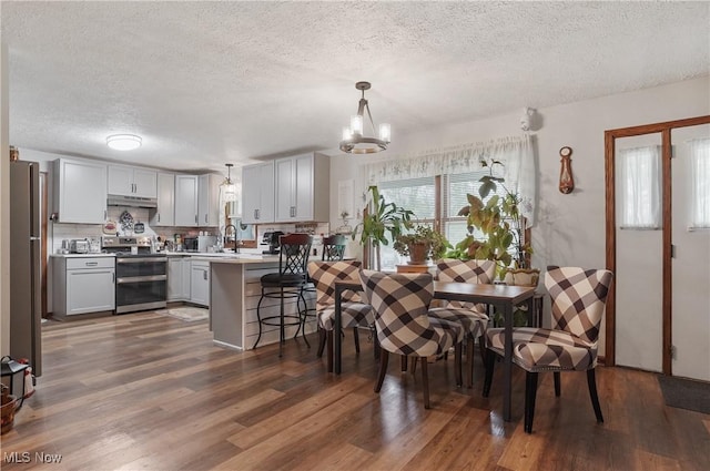 22010 Mountz Rd, Minerva, OH 44657 - dining area with a textured ceiling, dark wood-type flooring, and a chandelier