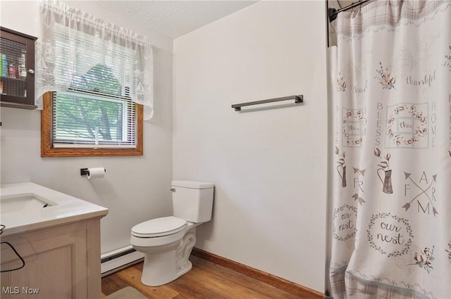 22010 Mountz Rd, Minerva, OH 44657 - full bath with a baseboard radiator, wood finished floors, toilet, vanity, and baseboards