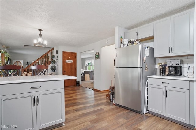 22010 Mountz Rd, Minerva, OH 44657 - kitchen with freestanding refrigerator, light wood-type flooring, a textured ceiling, light countertops, and a chandelier