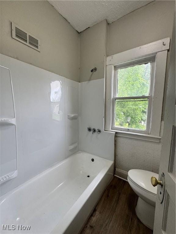 483 E 128th St, Cleveland, OH 44108 - full bath featuring wood finished floors, toilet, shower / tub combination, and a textured ceiling