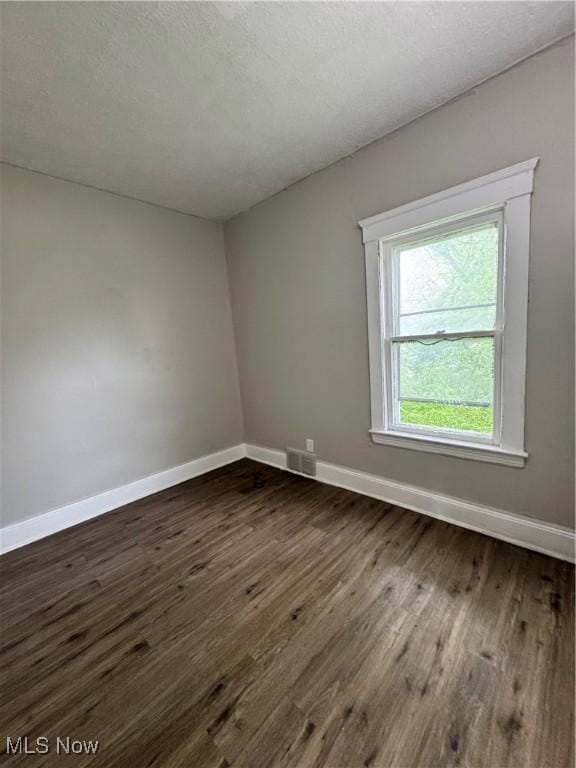 483 E 128th St, Cleveland, OH 44108 - spare room featuring dark wood finished floors and baseboards