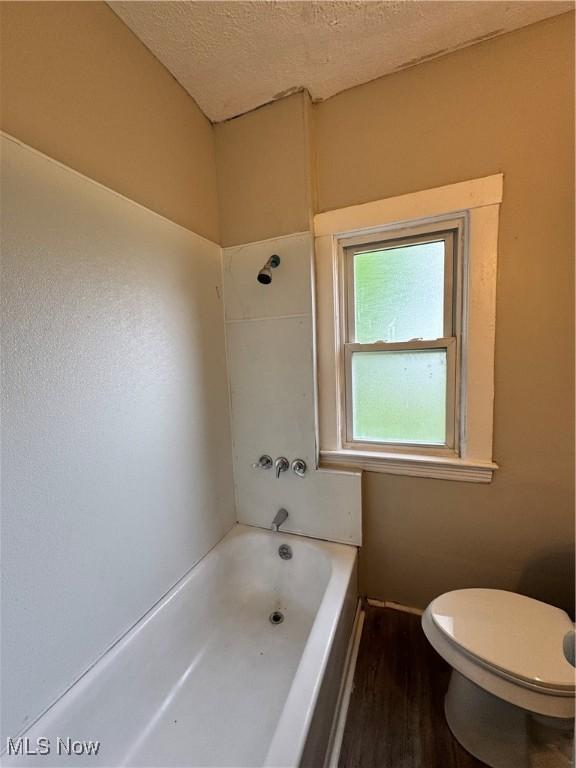 483 E 128th St, Cleveland, OH 44108 - full bath featuring toilet, wood finished floors, a textured ceiling, and shower / washtub combination