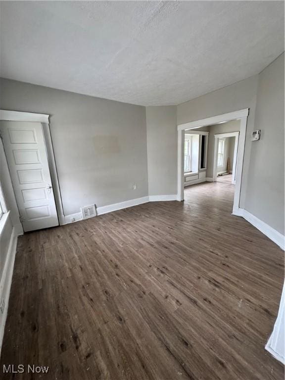483 E 128th St, Cleveland, OH 44108 - empty room with dark wood-type flooring, baseboards, and a textured ceiling