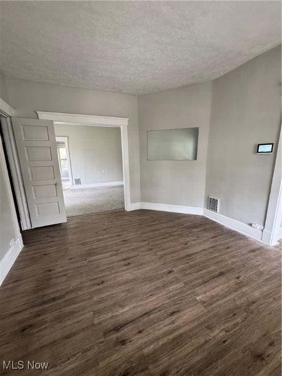 483 E 128th St, Cleveland, OH 44108 - empty room with dark wood finished floors, baseboards, and a textured ceiling