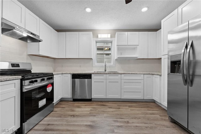 608 Arch St, Salem, OH 44460 - kitchen featuring appliances with stainless steel finishes, under cabinet range hood, a sink, a textured ceiling, and white cabinetry