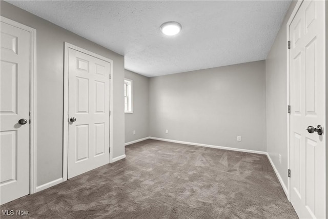 608 Arch St, Salem, OH 44460 - unfurnished bedroom with dark carpet, a textured ceiling, and baseboards