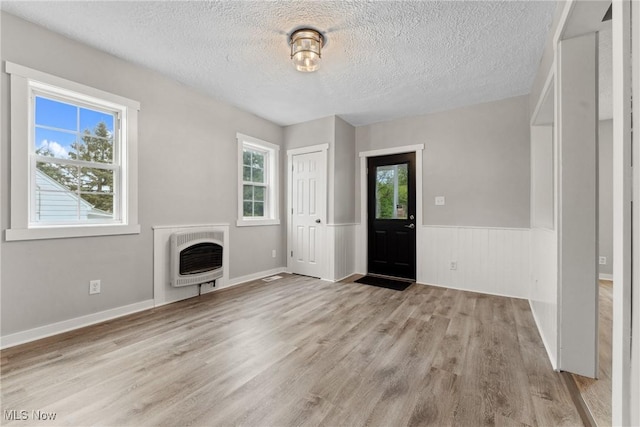 608 Arch St, Salem, OH 44460 - foyer entrance featuring heating unit, plenty of natural light, a textured ceiling, wood finished floors, and a fireplace