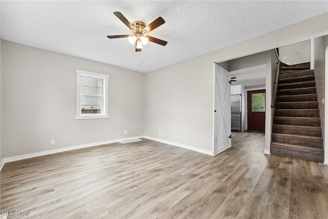 608 Arch St, Salem, OH 44460 - spare room with plenty of natural light, ceiling fan, wood finished floors, stairs, and a textured ceiling