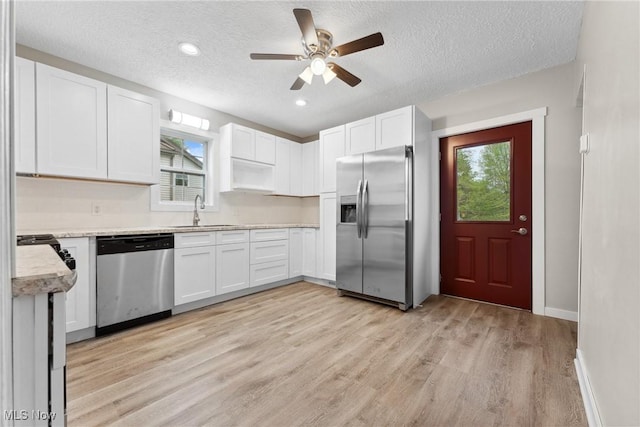608 Arch St, Salem, OH 44460 - kitchen featuring appliances with stainless steel finishes, a sink, healthy amount of natural light, light countertops, and a textured ceiling