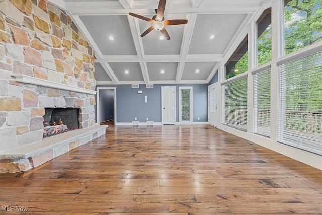 153 Cheyenne Trl, Malvern, OH 44644 - unfurnished living room featuring wood-type flooring, baseboards, ceiling fan, a stone fireplace, and beam ceiling