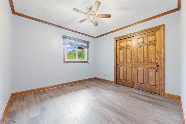153 Cheyenne Trl, Malvern, OH 44644 - unfurnished bedroom with baseboards, light wood-style flooring, crown molding, a textured ceiling, and ceiling fan