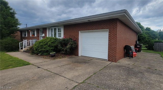 2126 Mctaggart St, Belpre, OH 45714 - view of front of home featuring a garage, driveway, and brick siding