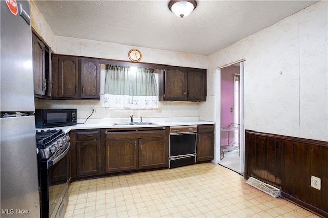 1580 S Hametown Rd, Copley, OH 44321 - kitchen with stainless steel appliances, a sink, light countertops, dark brown cabinets, and light floors