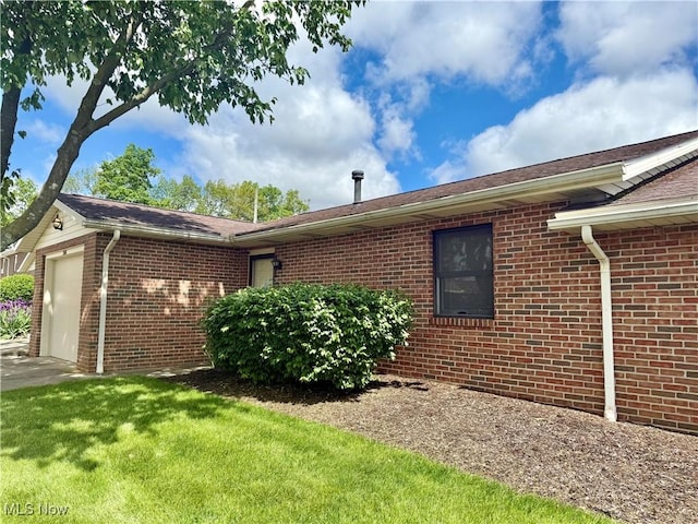 2518 Portage Grove Ct, Wooster, OH 44691 - view of property exterior with brick siding, an attached garage, and a lawn