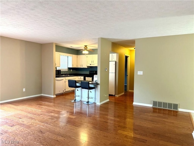 2518 Portage Grove Ct, Wooster, OH 44691 - kitchen featuring white appliances, wood finished floors, white cabinetry, a sink, and dark countertops