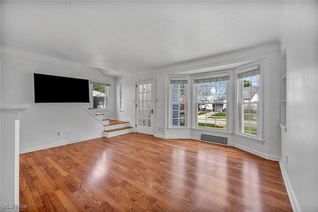 21650 Wilmore Ave, Euclid, OH 44123 - unfurnished living room featuring plenty of natural light, wood finished floors, baseboards, and stairs