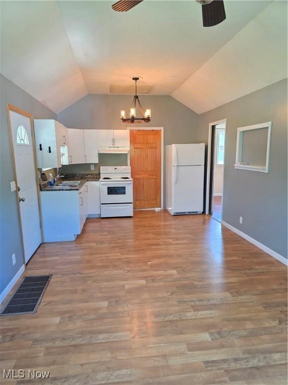719 Clark St, Philo, OH 43771 - kitchen with white appliances, lofted ceiling, white cabinets, dark countertops, and baseboards