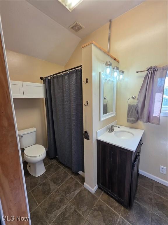 719 Clark St, Philo, OH 43771 - bathroom with vaulted ceiling, vanity, toilet, a shower with curtain, and tile patterned floors