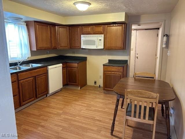 1131 Windermere Dr, Willoughby, OH 44094 - kitchen featuring white appliances, a sink, light wood-type flooring, dark countertops, and a textured ceiling