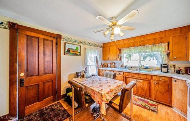 1092 State Route 46 N, Jefferson, OH 44047 - kitchen featuring light countertops, brown cabinetry, ceiling fan, light wood-type flooring, and a sink