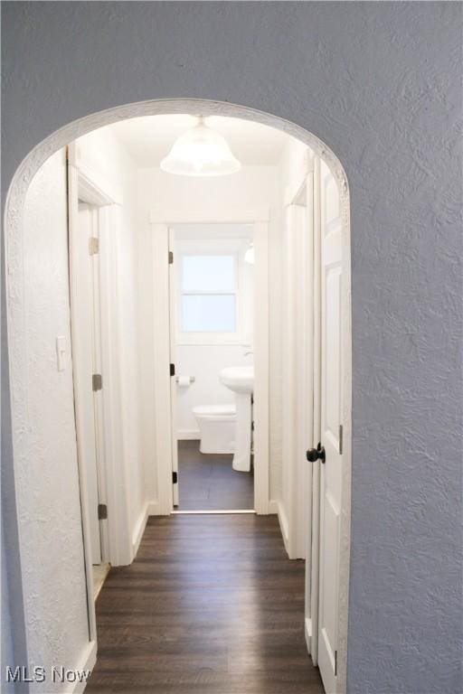 504 Williams Ave, East Liverpool, OH 43920 - hallway with a textured wall, arched walkways, and dark wood-style flooring