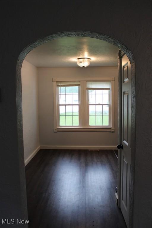 504 Williams Ave, East Liverpool, OH 43920 - spare room featuring arched walkways, dark wood-type flooring, and healthy amount of natural light