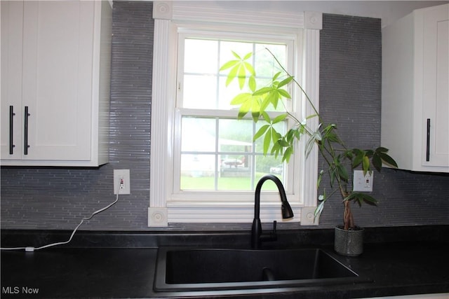 504 Williams Ave, East Liverpool, OH 43920 - kitchen featuring dark countertops, a sink, white cabinets, and tasteful backsplash