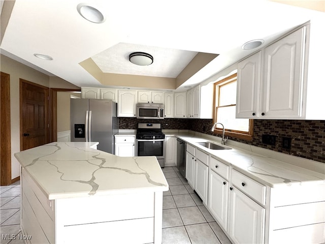 2761 Timberline Dr, Cortland, OH 44410 - kitchen featuring appliances with stainless steel finishes, a sink, light tile patterned floors, a center island, and decorative backsplash