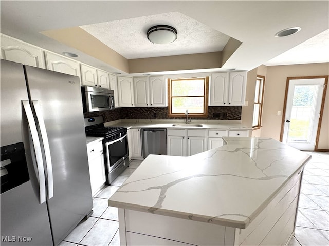 2761 Timberline Dr, Cortland, OH 44410 - kitchen featuring appliances with stainless steel finishes, a sink, backsplash, light tile patterned floors, and a kitchen island