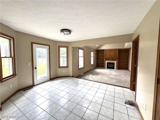 2761 Timberline Dr, Cortland, OH 44410 - unfurnished living room with built in features, a fireplace, light tile patterned floors, baseboards, and a textured ceiling