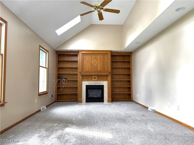 2761 Timberline Dr, Cortland, OH 44410 - unfurnished living room featuring carpet, a glass covered fireplace, ceiling fan, a skylight, and high vaulted ceiling