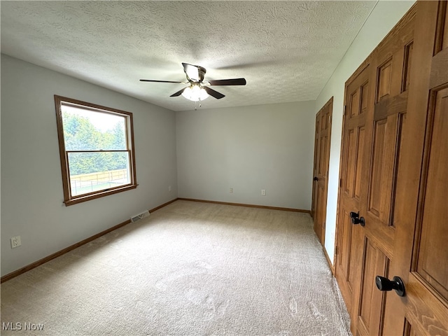 2761 Timberline Dr, Cortland, OH 44410 - unfurnished room featuring light carpet, ceiling fan, baseboards, and a textured ceiling