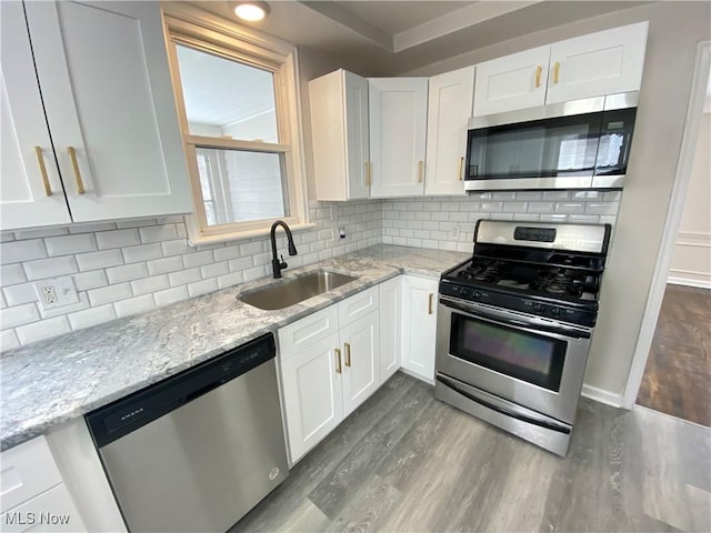4485 Baintree Rd, University Heights, OH 44118 - kitchen with appliances with stainless steel finishes, a sink, dark wood-style flooring, white cabinetry, and light stone counters
