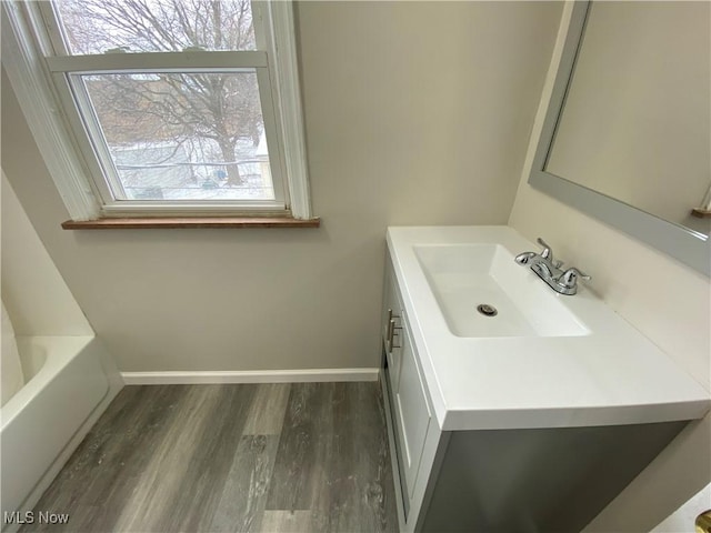 4485 Baintree Rd, University Heights, OH 44118 - full bath featuring vanity, wood finished floors, a tub, and baseboards
