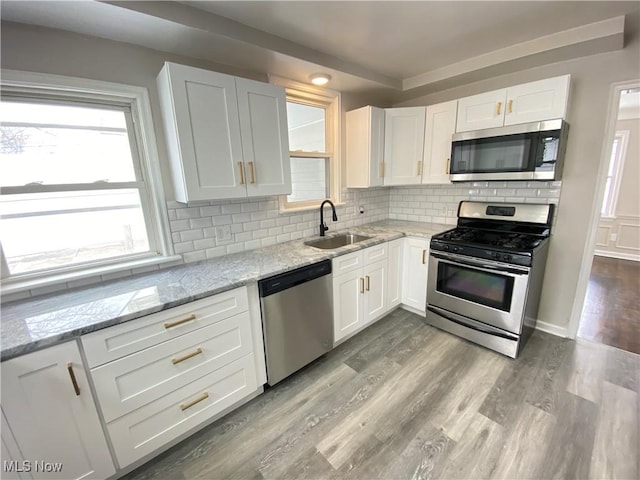 4485 Baintree Rd, University Heights, OH 44118 - kitchen with appliances with stainless steel finishes, a sink, white cabinetry, and tasteful backsplash