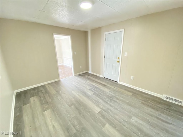 4485 Baintree Rd, University Heights, OH 44118 - unfurnished room with wood finished floors, baseboards, and a paneled ceiling