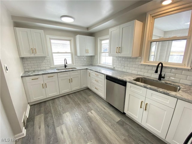 4485 Baintree Rd, University Heights, OH 44118 - kitchen with stainless steel dishwasher, a sink, wood finished floors, and white cabinetry