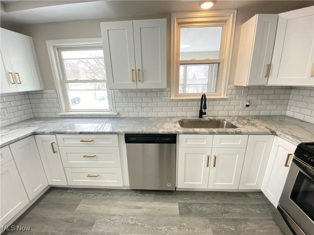 4485 Baintree Rd, University Heights, OH 44118 - kitchen with appliances with stainless steel finishes, a sink, white cabinets, and healthy amount of natural light