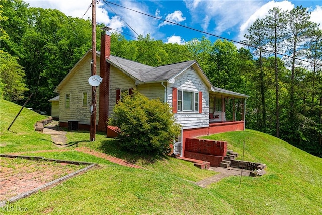 18288 Township Rd Unit 284, Coshocton, OH 43812 - view of home's exterior with a chimney, a yard, and central AC