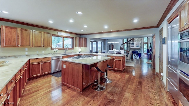 5360 Som Center Rd, Solon, OH 44139 - kitchen featuring stainless steel appliances, crown molding, a peninsula, a sink, and a kitchen bar