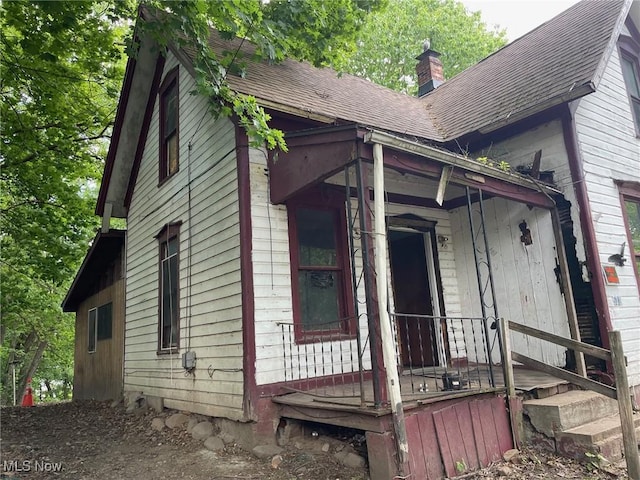 532 4th St SW, Massillon, OH 44647 - view of side of property with a shingled roof and a chimney