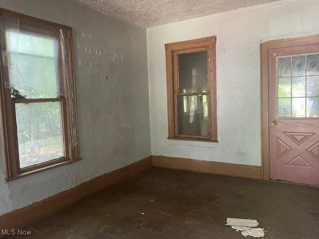 532 4th St SW, Massillon, OH 44647 - empty room with a textured ceiling, plenty of natural light, and baseboards