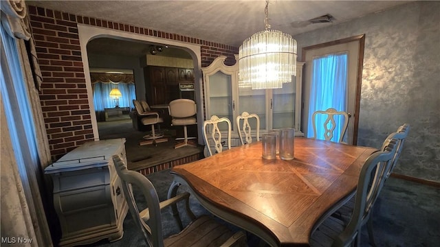 2941 Regal Dr NW, Warren, OH 44485 - carpeted dining space featuring a chandelier, arched walkways, and baseboards