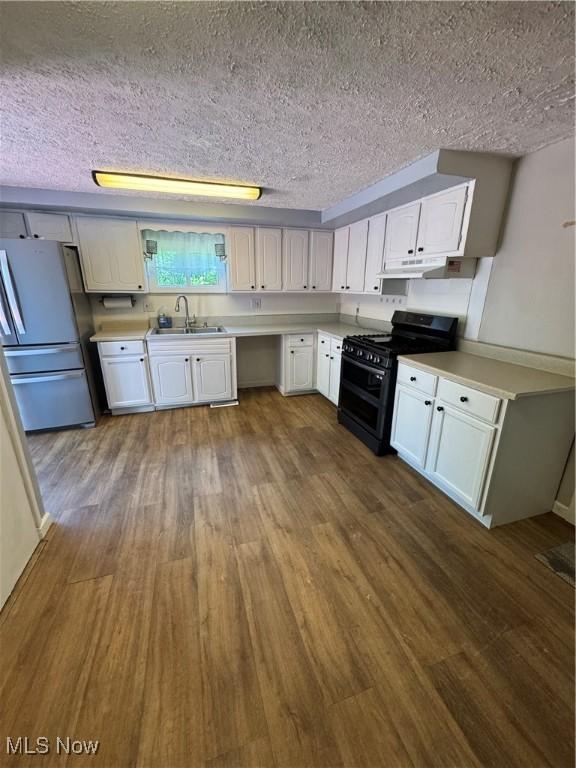 4940 State Route 26, Marietta, OH 45750 - kitchen featuring freestanding refrigerator, double oven range, a sink, wood finished floors, and white cabinets