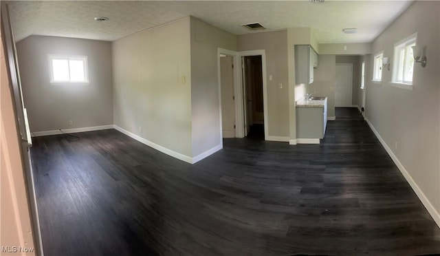 2824 Brenner Dr, Lorain, OH 44053 - empty room with dark wood finished floors, baseboards, a sink, and a textured ceiling