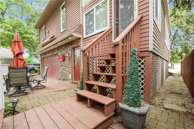 13817 Lakewood Heights Blvd, Lakewood, OH 44107 - wooden deck with a patio, stairs, a garage, and outdoor dining area