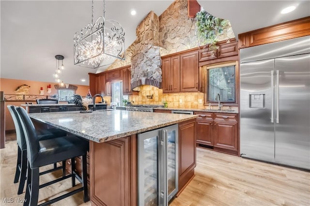 13817 Lakewood Heights Blvd, Lakewood, OH 44107 - kitchen featuring built in fridge, wine cooler, a sink, tasteful backsplash, and light stone counters