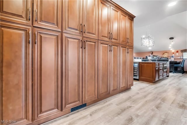 13817 Lakewood Heights Blvd, Lakewood, OH 44107 - kitchen featuring beverage cooler, brown cabinets, a chandelier, and light wood-style floors