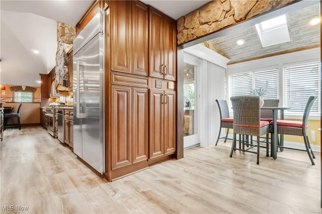 13817 Lakewood Heights Blvd, Lakewood, OH 44107 - kitchen featuring stainless steel appliances, light wood finished floors, brown cabinetry, recessed lighting, and lofted ceiling